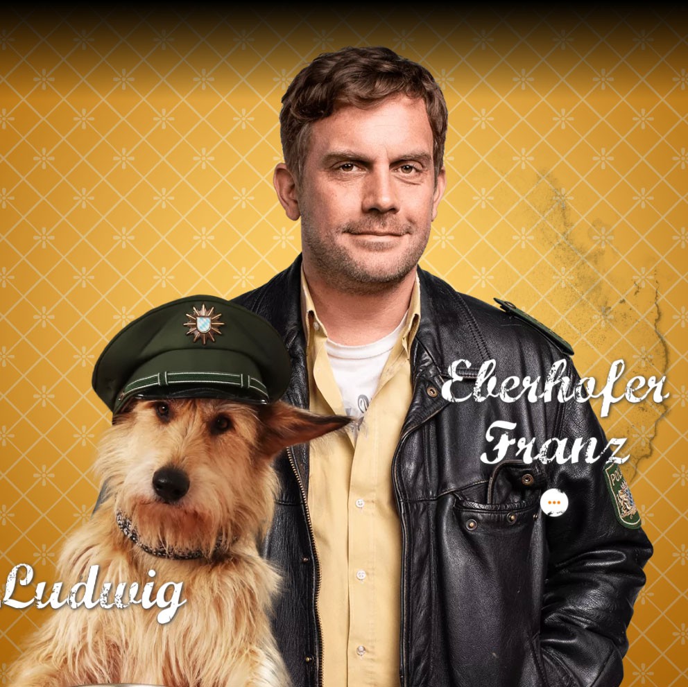 Franz Eberhofer und sein Hund Ludwig, der eine Polizeimütze trägt.