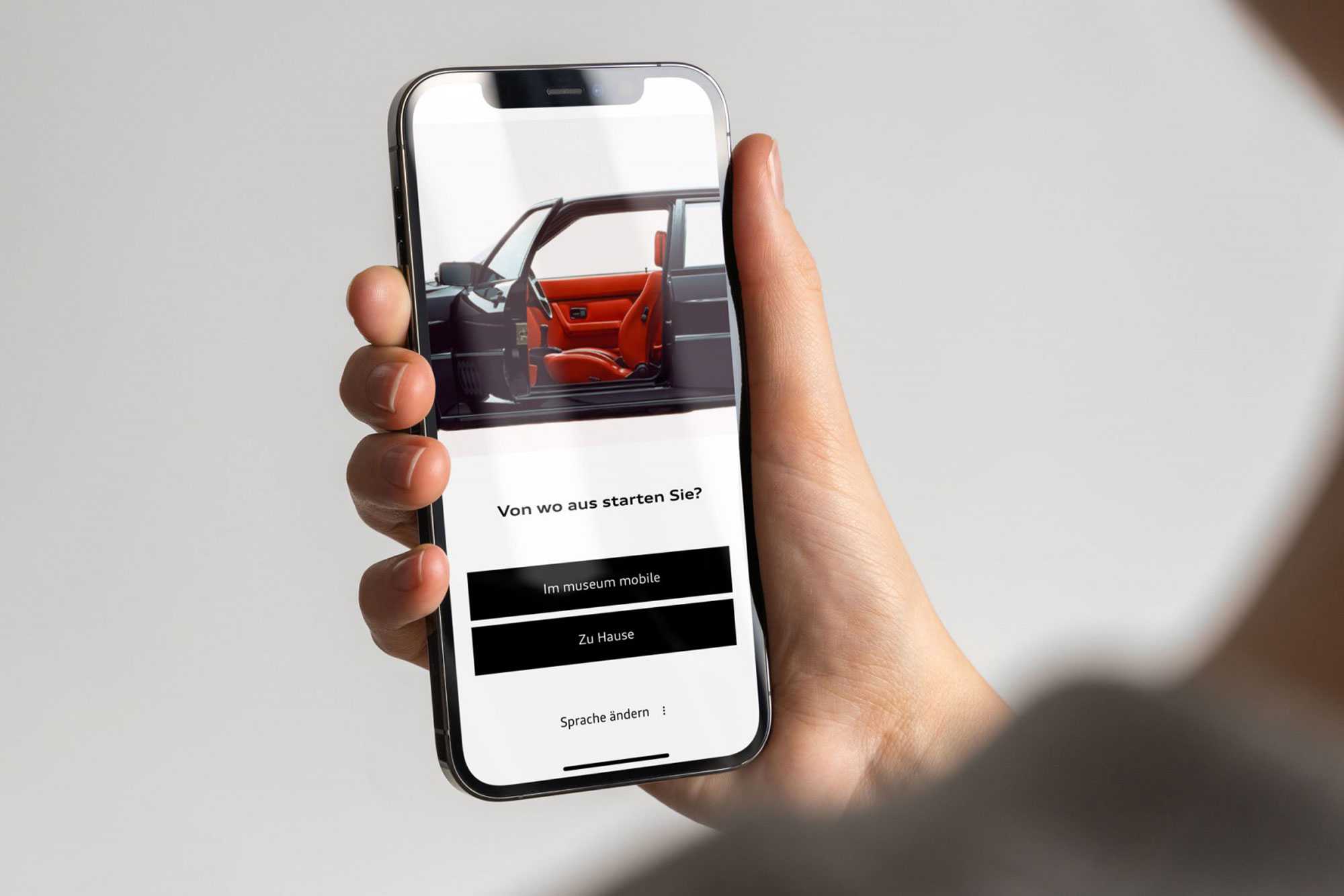 Hand hält Smartphone. Geöffnete App: Audi Tradition App